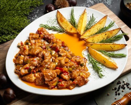 Plato de receta de lagarto de cerdo con pisto casero y patatas