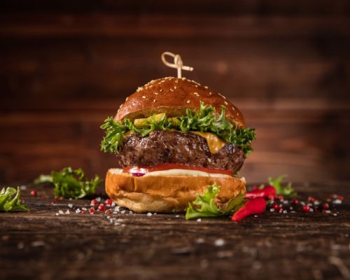 Plato de hamburguesa de cerdo madurada con salsa de queso y pepinillos