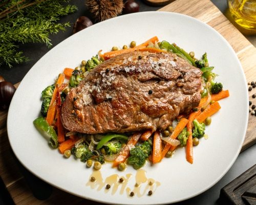 Plato con presa de cerdo en salsa de miel y pimienta con verduras, con cerdo de Castañas