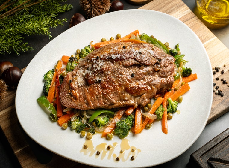 Plato con presa de cerdo en salsa de miel y pimienta con verduras, con cerdo de Castañas